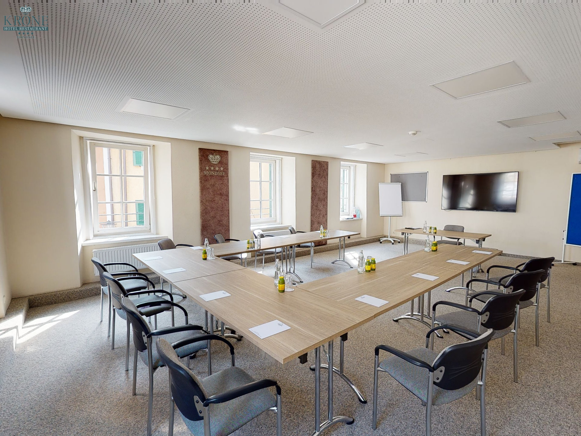 Brightly lit seminar room with screen and blackboards for meetings.
